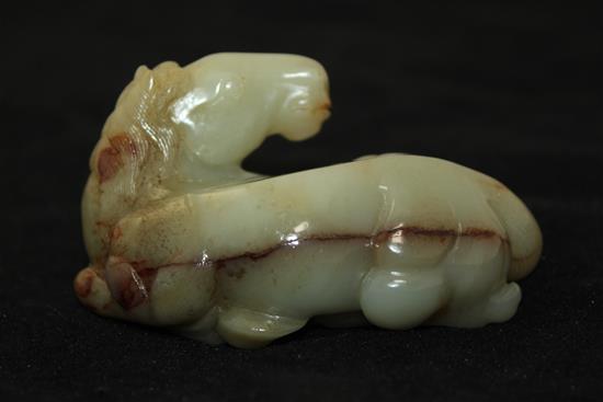 A Chinese celadon and brown jade figure of a recumbent horse, 20th century, 9.5cm